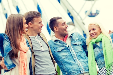 group of smiling friends in amusement park